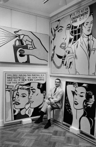 Roy Lichtenstein at Castelli Gallery sitting with Spray (1962), Masterpiece (1962), Engagement Ring (1961) and Aloha (1962), 1962. Photograph by Bill Ray